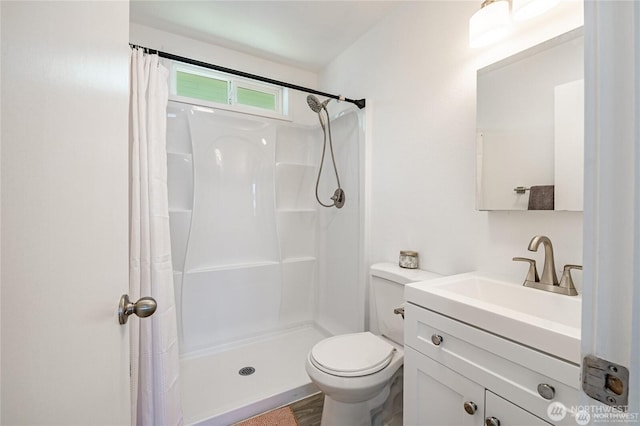 bathroom with curtained shower, toilet, and vanity