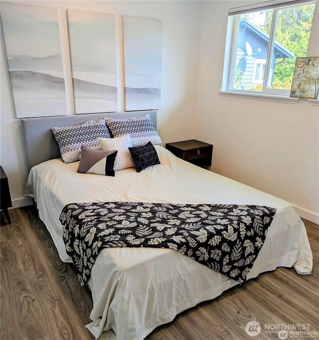 bedroom featuring baseboards and wood finished floors