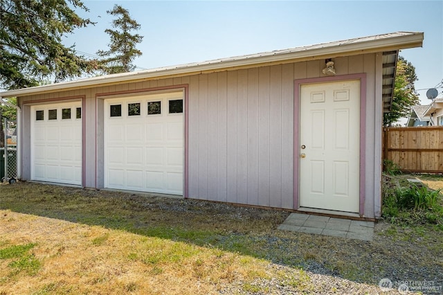 detached garage featuring fence