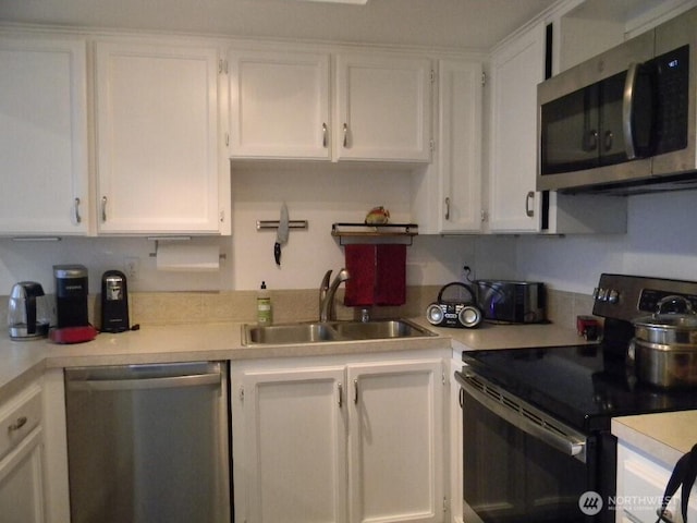 kitchen with a sink, light countertops, white cabinetry, and stainless steel appliances