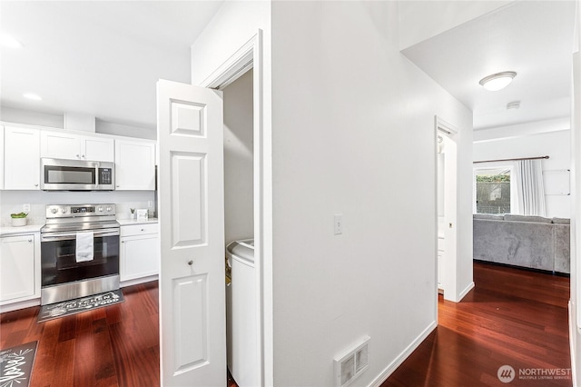 kitchen with dark wood-style floors, visible vents, white cabinets, and appliances with stainless steel finishes