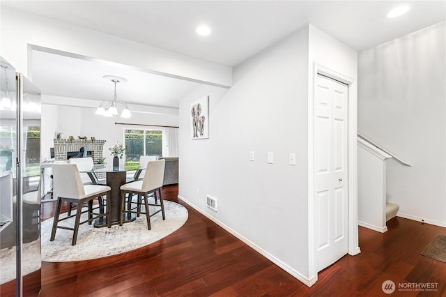 dining space with stairs, a notable chandelier, wood finished floors, and baseboards