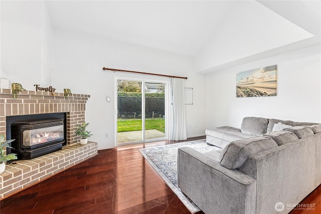 living area with a brick fireplace, high vaulted ceiling, baseboards, and wood finished floors