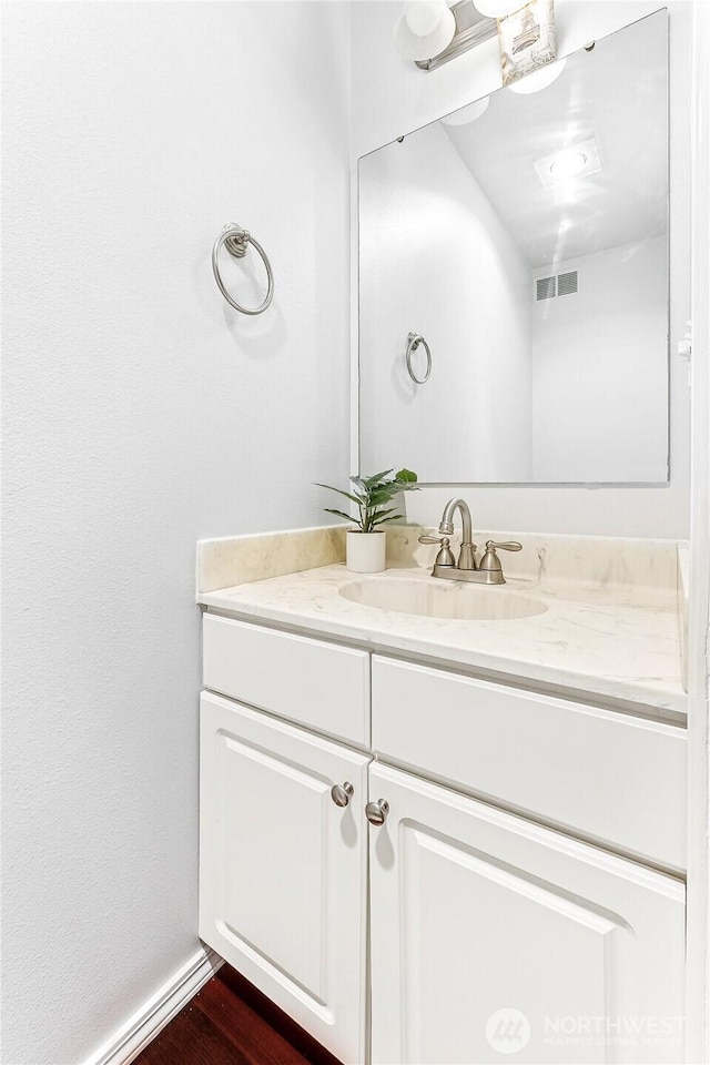 bathroom featuring visible vents, wood finished floors, and vanity