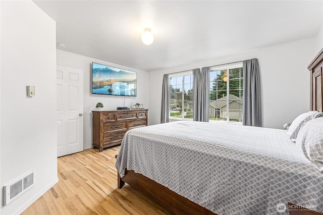 bedroom featuring light wood-style flooring, baseboards, and visible vents