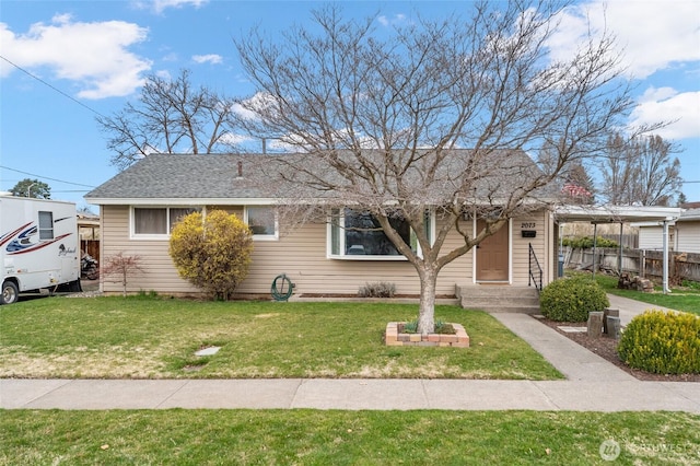 view of front of home featuring a front yard and a shingled roof