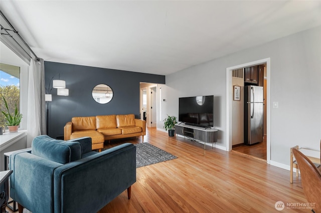 living room with light wood-type flooring and baseboards