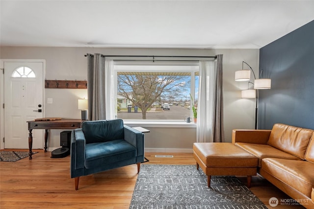 sitting room featuring visible vents, baseboards, and wood finished floors