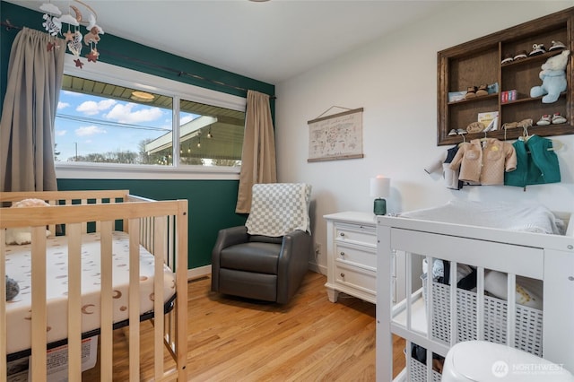 bedroom featuring baseboards and light wood finished floors