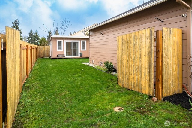 back of property with a lawn and a fenced backyard