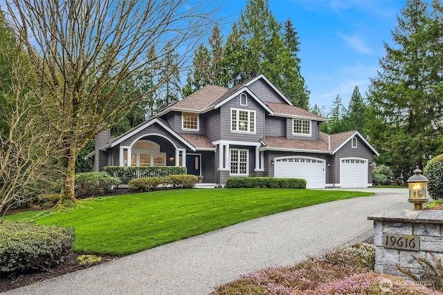 view of front of property with driveway, an attached garage, a front yard, and roof with shingles