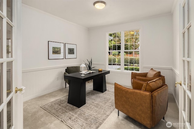 carpeted office with a wainscoted wall and crown molding