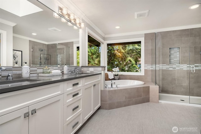 full bathroom with double vanity, a skylight, ornamental molding, a shower stall, and a bath