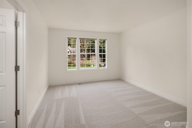 unfurnished room with baseboards and carpet flooring