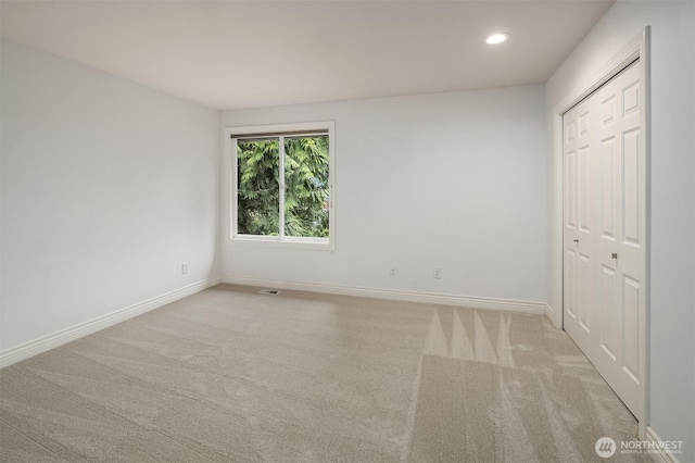 unfurnished bedroom with a closet, recessed lighting, baseboards, and carpet floors