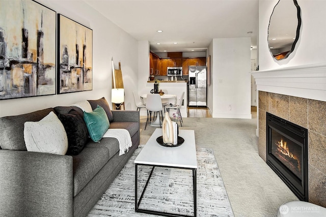 living area featuring recessed lighting, baseboards, light colored carpet, and a tiled fireplace