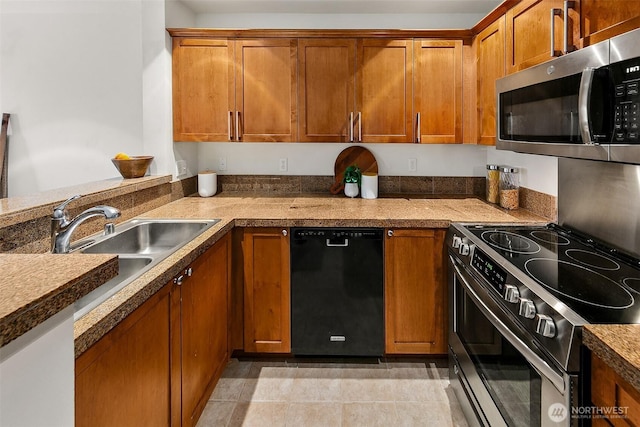 kitchen featuring brown cabinets, stainless steel appliances, and a sink