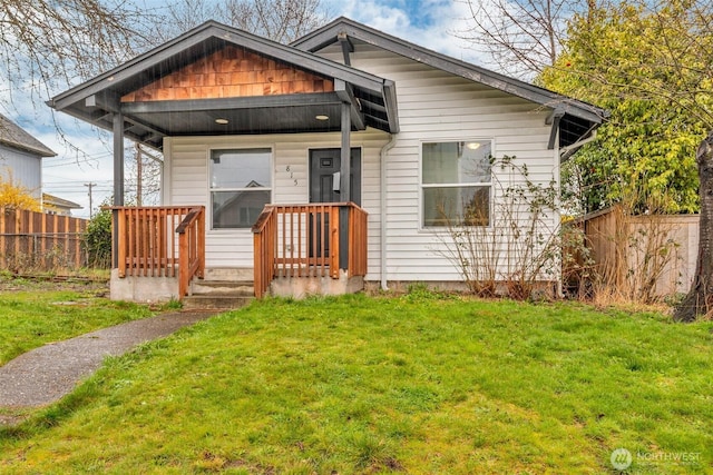 bungalow-style house with a front yard and fence