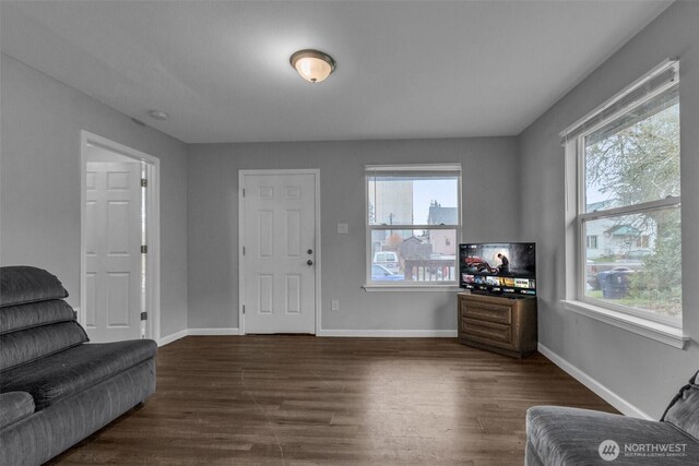 living room featuring baseboards and dark wood finished floors
