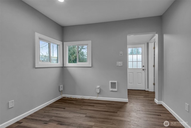 empty room with baseboards and dark wood-style floors