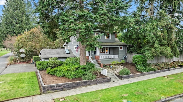 view of front of property featuring a front lawn, a porch, fence, roof with shingles, and stairs