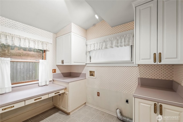 laundry area with wallpapered walls, cabinet space, hookup for an electric dryer, and light floors