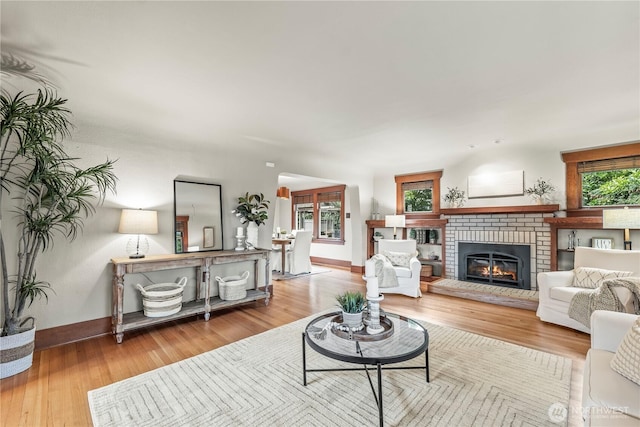 living room with baseboards, wood finished floors, and a fireplace