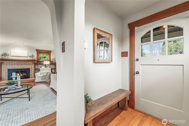 interior space with light wood-type flooring and a brick fireplace