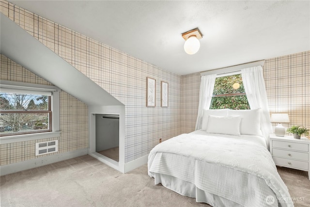 bedroom featuring tile walls, carpet, baseboards, and lofted ceiling