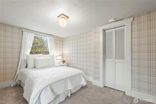 bedroom with tile walls, carpet flooring, and a closet