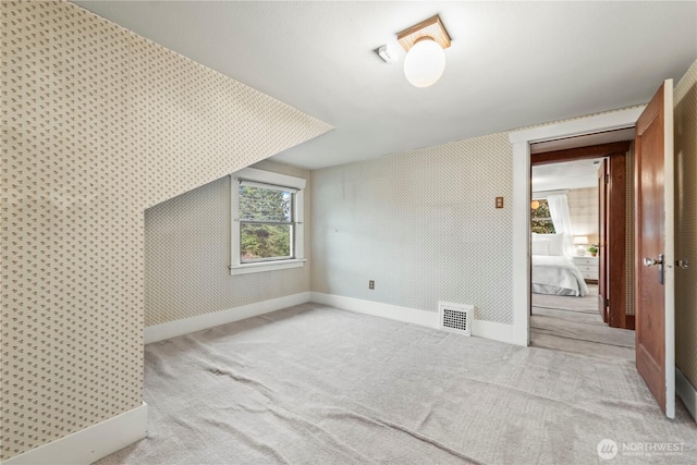 bonus room with visible vents, wallpapered walls, baseboards, and carpet floors