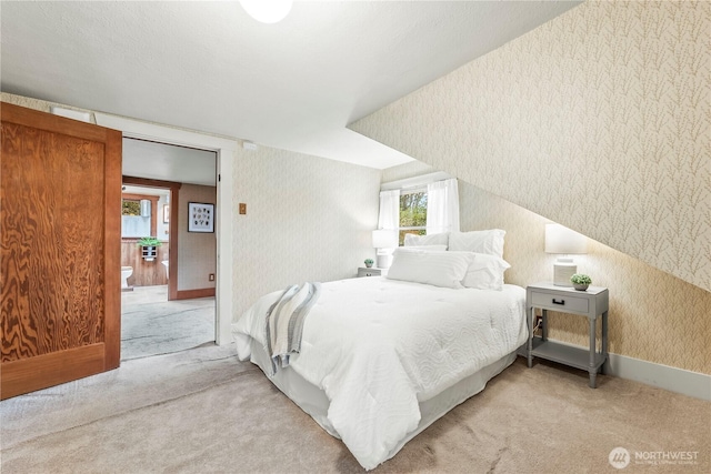 carpeted bedroom featuring wallpapered walls and baseboards