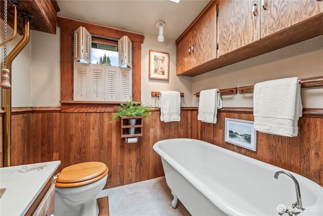 bathroom featuring a soaking tub, wooden walls, and a wainscoted wall