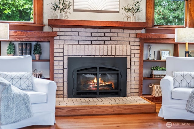 details featuring a brick fireplace and wood finished floors