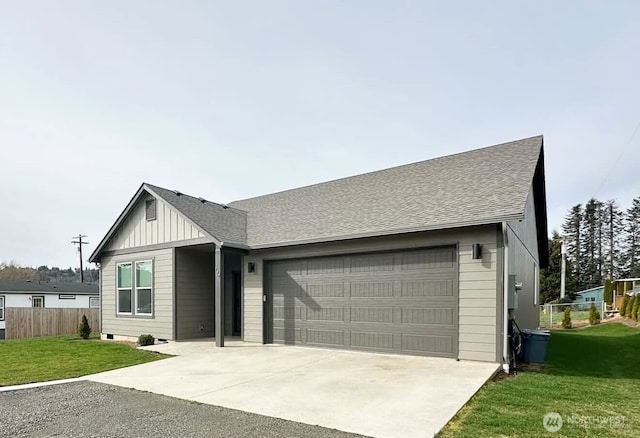 view of front of house with a front yard, fence, concrete driveway, a garage, and board and batten siding