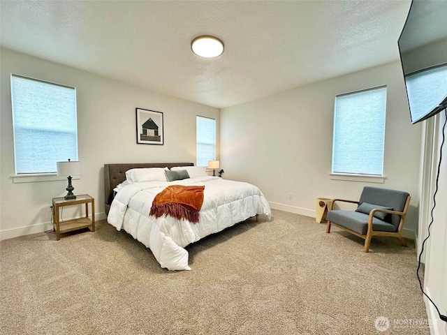 carpeted bedroom featuring baseboards and a textured ceiling