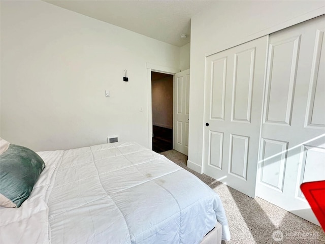 bedroom featuring a closet, carpet flooring, and visible vents