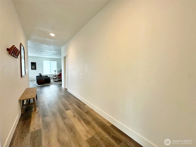 hall featuring baseboards and wood finished floors