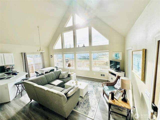 living room with a notable chandelier, visible vents, high vaulted ceiling, and light wood-style floors