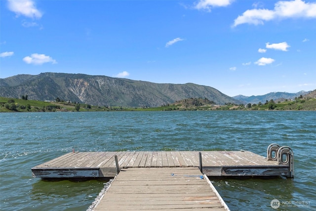 view of dock with a water and mountain view