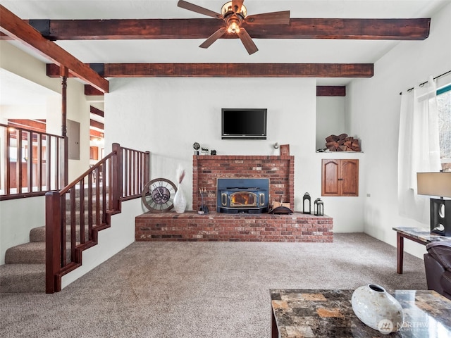 living room featuring stairs, beamed ceiling, carpet floors, and a wood stove