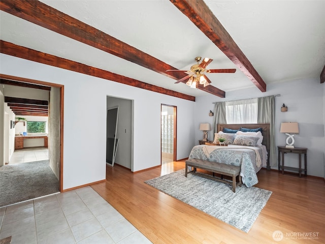 bedroom with beam ceiling, a ceiling fan, baseboards, and light wood finished floors