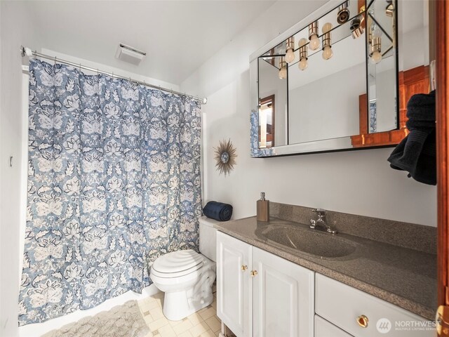 full bathroom featuring vanity, curtained shower, and toilet