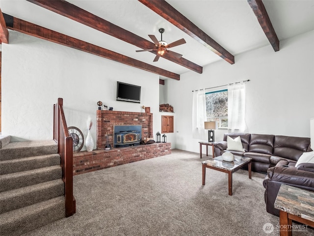 carpeted living room featuring beamed ceiling, stairs, and a ceiling fan