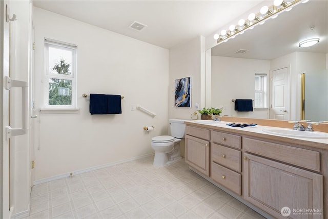 bathroom featuring a sink, visible vents, baseboards, and double vanity