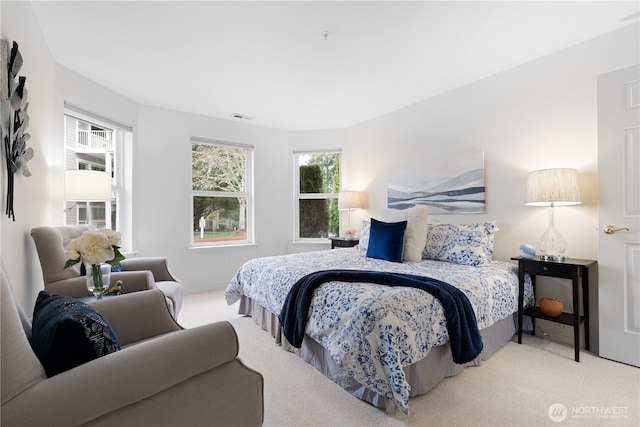 carpeted bedroom featuring visible vents