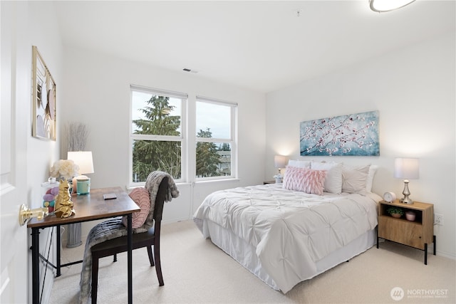 bedroom with light colored carpet, visible vents, and baseboards