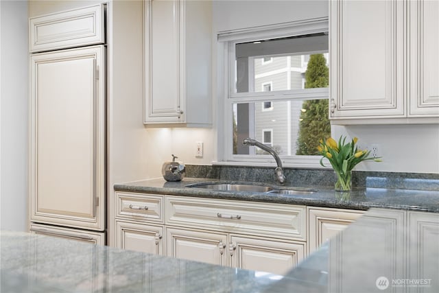 kitchen with dark stone countertops and a sink