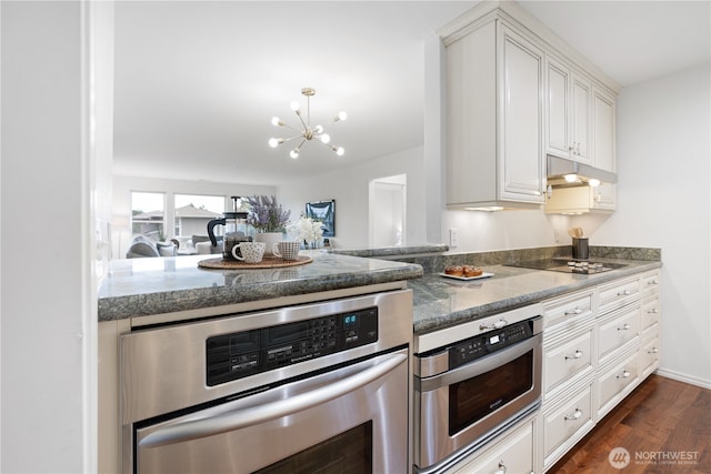 kitchen with black electric stovetop, under cabinet range hood, stainless steel oven, dark wood-style floors, and white cabinetry