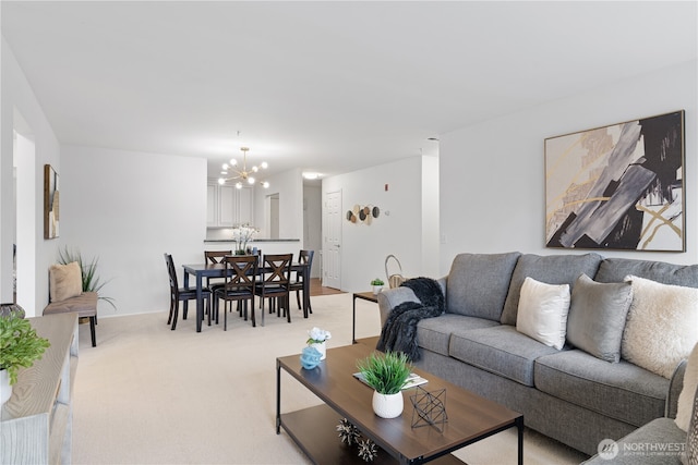 living area with a notable chandelier and light carpet